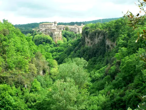 Un borgo medievale arroccato su una rupe domina le verdi gole del Biedano, immerse in una lussureggiante vegetazione.