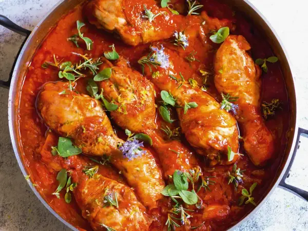 Pollo alla viterbese in padella, con salsa rossa, erbe aromatiche e scorza di limone.