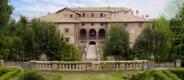 Villa Giustiniani Bassano Romano: imponente residenza storica circondata da verde, con scalinata e loggiato ad archi.