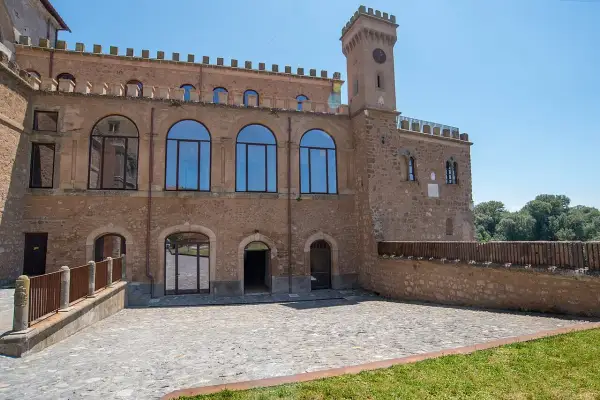 Il **Palazzo Doebbing**, con la sua torre dell'orologio e le ampie finestre ad arco, si affaccia su un cortile lastricato sotto un cielo azzurro.