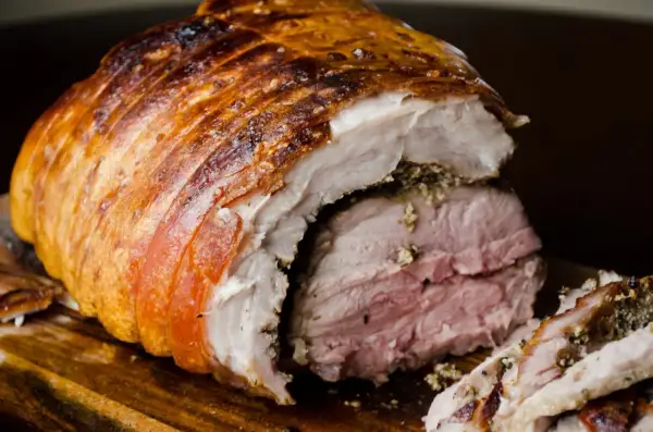 Porchetta viterbese succulenta, con crosta dorata e carne rosata, pronta per essere gustata.