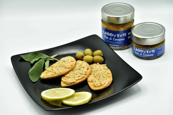 Bruschette con paté di coregone bolsena, olive verdi, limone e salvia. Due vasetti di paté di coregone in primo piano.