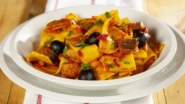 Piatto di fregnacce con sugo di pomodoro, olive nere e carne. Una deliziosa ricetta da provare subito!